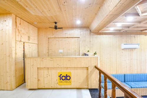 Cette chambre en bois comprend une table et un canapé bleu. dans l'établissement FabHotel Royal Metro, à Amritsar