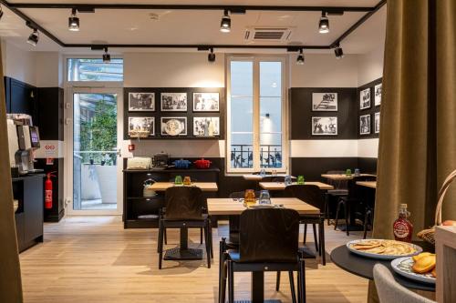 ブローニュ・ビヤンクールにあるDantan Hôtelの部屋にテーブルと椅子があるレストラン