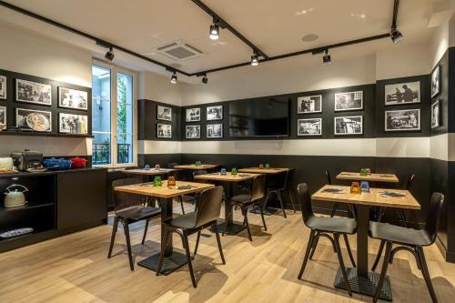 ブローニュ・ビヤンクールにあるDantan Hôtelの部屋にテーブルと椅子があるレストラン