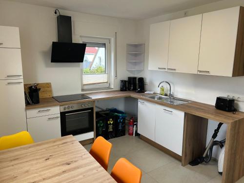 a kitchen with white cabinets and a wooden counter top at Ferienwohnung Eyb in Ansbach