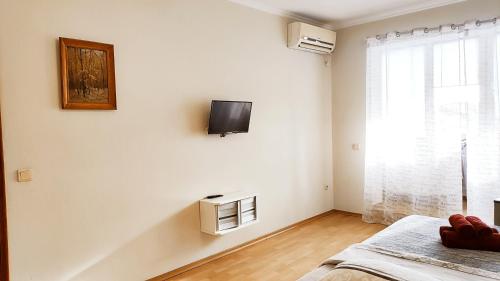 a white room with a tv on the wall at Олександрійський б-р 125 CityRooms in Bila Tserkva