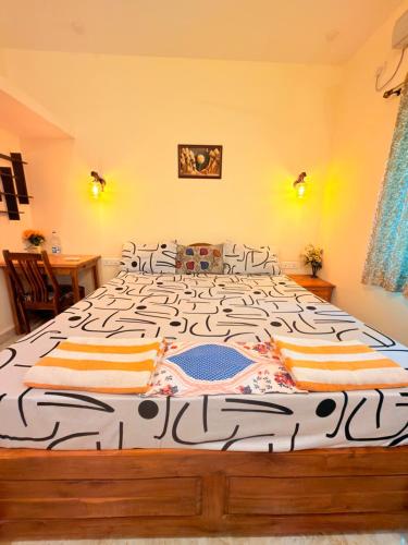 a large bedroom with a large bed with a black and white bedspread at SAI HOMESTAY in Agonda