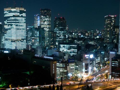 Una ciudad iluminada por la noche con tráfico en Toshi Center Hotel, en Tokio
