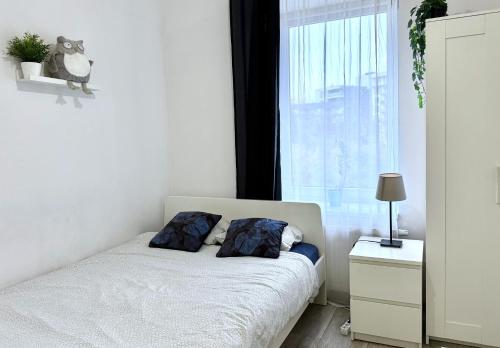 een slaapkamer met een bed met twee kussens en een raam bij theApartments Manufaktura in Łódź