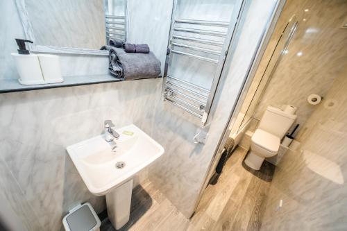 a bathroom with a sink and a toilet at Exquisite Serviced Studio @ Greenhead Central in Huddersfield