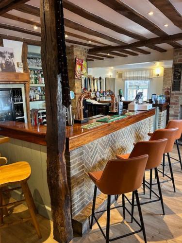 FreckenhamにあるThe Golden Boar Innのレストラン内にスツールが並んだバー
