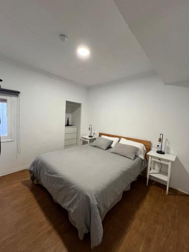a white bedroom with a large bed and two tables at El Rincón Azul in Jalance
