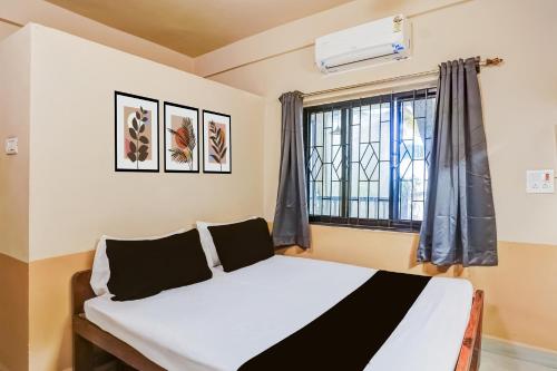 een slaapkamer met een bed en een raam bij Hotel O Arambol Beach Formerly Hakuna Matata in Arambol