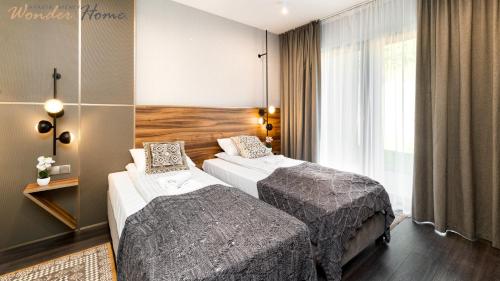 une chambre d'hôtel avec deux lits et une fenêtre dans l'établissement Wonder Hill - apartamenty z klimatyzacją, balkonami lub trasami, à Sosnówka