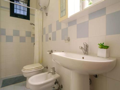 a white bathroom with a sink and a toilet at Costal Vibe in Isola della Malva