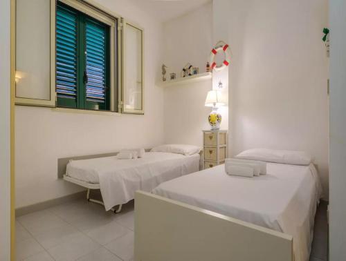 a white room with two beds and a window at Costal Vibe in Isola della Malva