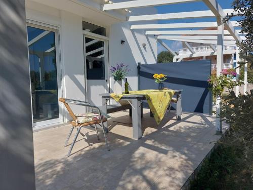 a table and a chair on a patio at House Piloda in Néa Thésis