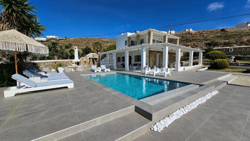 a villa with a swimming pool in front of a house at Villa "Kalli" with private pool - beachfront - Kalo Livadi in Kalo Livadi