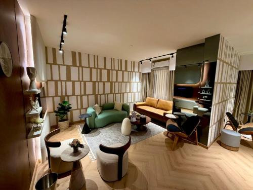 a living room with a green couch and chairs at D3S 3BR Apartment in Makkah