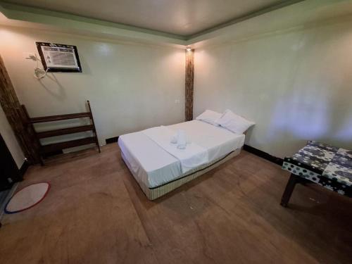 a small bedroom with a bed and a table at Izzahjay homestay in Burgos