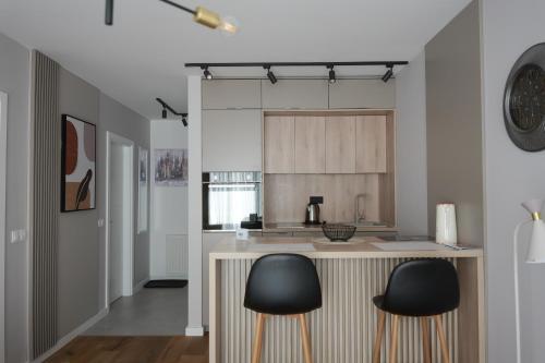 a kitchen with two black chairs at a counter at Apartment Nuve in Bjelašnica