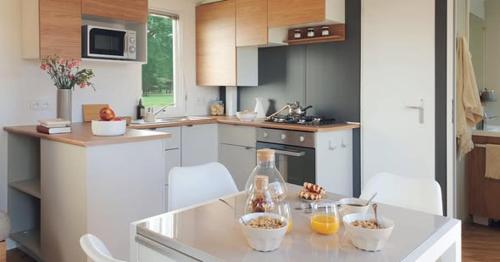 een keuken met een aanrecht met kommen eten erop bij Mobil Home 40m2, Bonne Anse Siblu 4 étoiles in Les Mathes