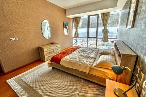 a bedroom with a bed and a large window at Premium Vacation Home in Old Dubai Nr Metro Mall in Dubai