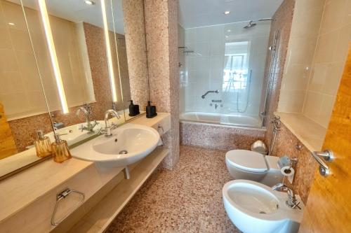 a bathroom with two sinks and a toilet and a tub at Premium Vacation Home in Old Dubai Nr Metro Mall in Dubai