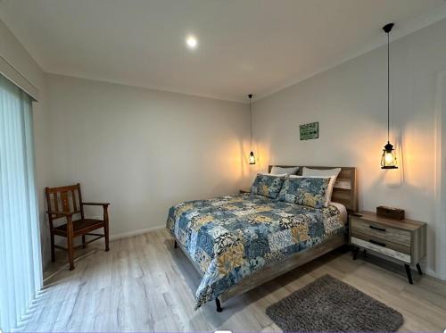 a bedroom with a bed and a table and a chair at Blueberry Hills On Comleroy Farmstay - Self-Contained Cottages in Kurrajong