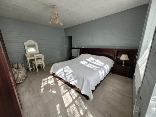 Un dormitorio con una cama, una mesa y un espejo. en Gite chez Matos 3 chambres, en Cellettes