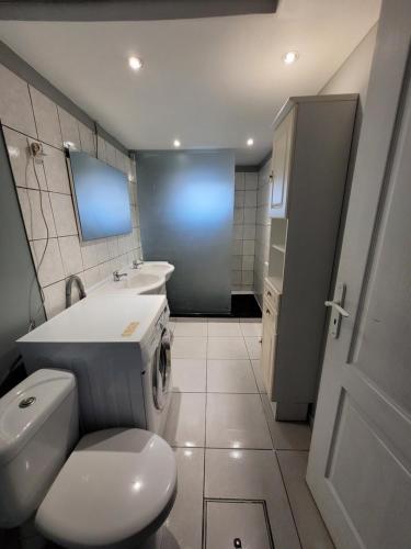 Un baño con un inodoro blanco y un lavabo. en Gite chez Matos 3 chambres, en Cellettes