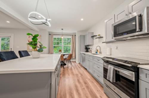 a kitchen with white cabinets and a counter top at Spacious House with King Beds in Prime Location in Bloomfield