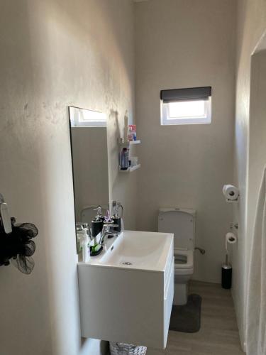 a white bathroom with a sink and a toilet at The Villa On Fontana in Yzerfontein