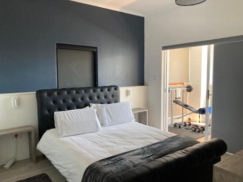 a bedroom with a large bed with a leather headboard at The Villa On Fontana in Yzerfontein