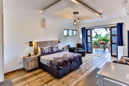 a bedroom with a large bed and a living room at Van Gogh in Ballito