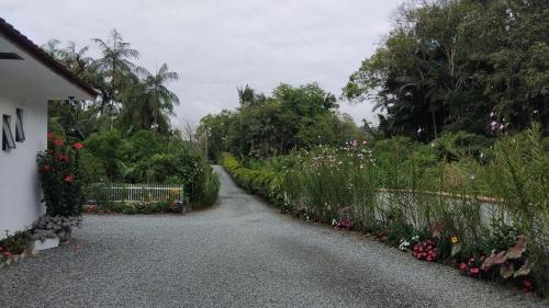 a gravel driveway with flowers in a garden at Recanto Área Verde, tradição e cultura alemã in Pomerode