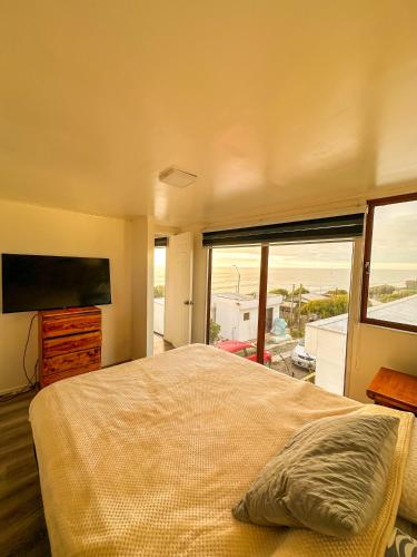 Un dormitorio con una cama grande y una ventana grande en Cabañas del Sol, en La Boca