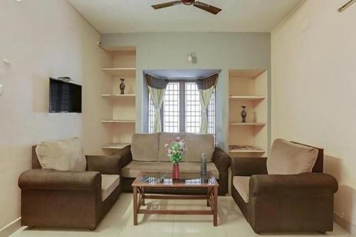 a living room with two couches and a coffee table at Via Blue Moon Residency in Chennai