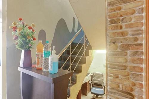 a staircase with bottles and flowers on a table at Via Blue Moon Residency in Chennai