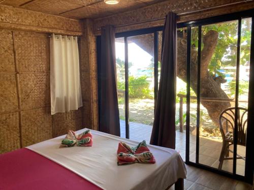 a bedroom with a bed with two bow ties on it at Amami Beachfront Bungalows & Villa in Puerto Galera