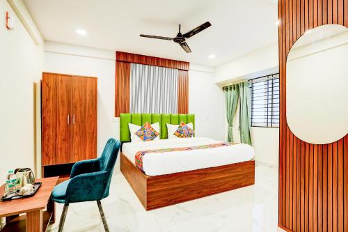 a bedroom with a bed and a desk and a chair at FabHotel Leon Square in Bengaluru