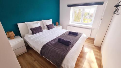 ein Schlafzimmer mit einem großen weißen Bett und lila Kissen in der Unterkunft Les gîtes de Rozélie in Gembloux