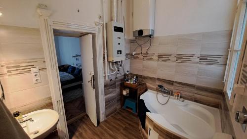 a bathroom with a tub and a toilet and a sink at Gaia Astoria in Budapest