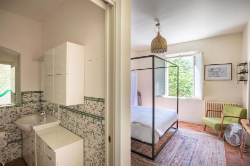 ein Badezimmer mit Waschbecken und ein Bett in einem Zimmer in der Unterkunft 16th Century Townhouse, Large Garden Near Lake, Tuscany and Umbria - Sleeps 18 in Gioiella