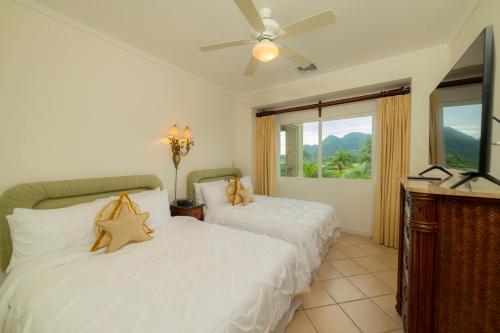 ein Schlafzimmer mit zwei Betten und einem Deckenventilator in der Unterkunft Del Mar 4G 3 bdr Garden View in Los Suenos in Herradura