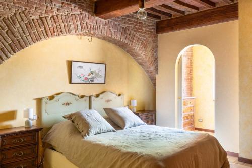 ein Schlafzimmer mit einem großen Bett mit Ziegelwand in der Unterkunft 16th Century Townhouse, Large Garden Near Lake, Tuscany and Umbria - Sleeps 18 in Gioiella