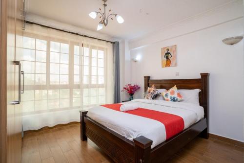 a bedroom with a large bed and a window at Luxurious Nairobi Apartment with Shared Pool and Modern Amenities in Nairobi