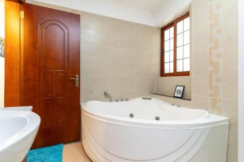 a bathroom with a large tub and a sink at Luxurious Nairobi Apartment with Shared Pool and Modern Amenities in Nairobi