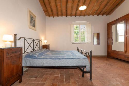 ein Schlafzimmer mit einem Bett, einer Kommode und einem Fenster in der Unterkunft Agriturismo La Gatta E L'Olivo in Donoratico