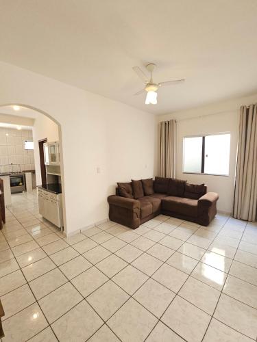 a living room with a couch and a tile floor at Casa com ar-condicionado no centro da cidade, bem localizada, 10min da praia a pé in Prado