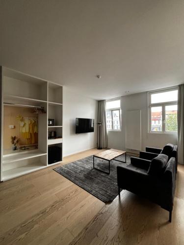 a living room with a couch and a tv at Namur Suites in Mellet