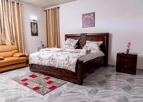 een slaapkamer met een bed en een stoel erin bij The Victory Residence in Accra