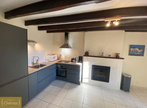 una cucina con lavello e fornello forno superiore di Cottage Cèdres - Maison chaleureuse à la campagne avec jardin a Héric