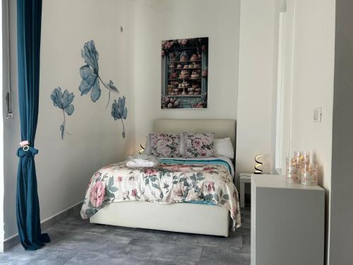 a bedroom with a bed with a floral bedspread at Seaside two-room apartment in Torvaianica