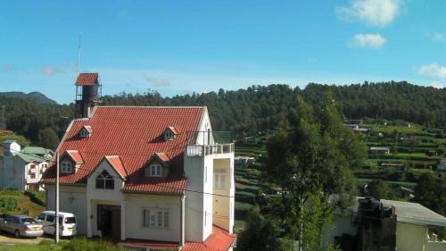 a house with a red roof on a hill at The Niwasa Resident in Nuwara Eliya